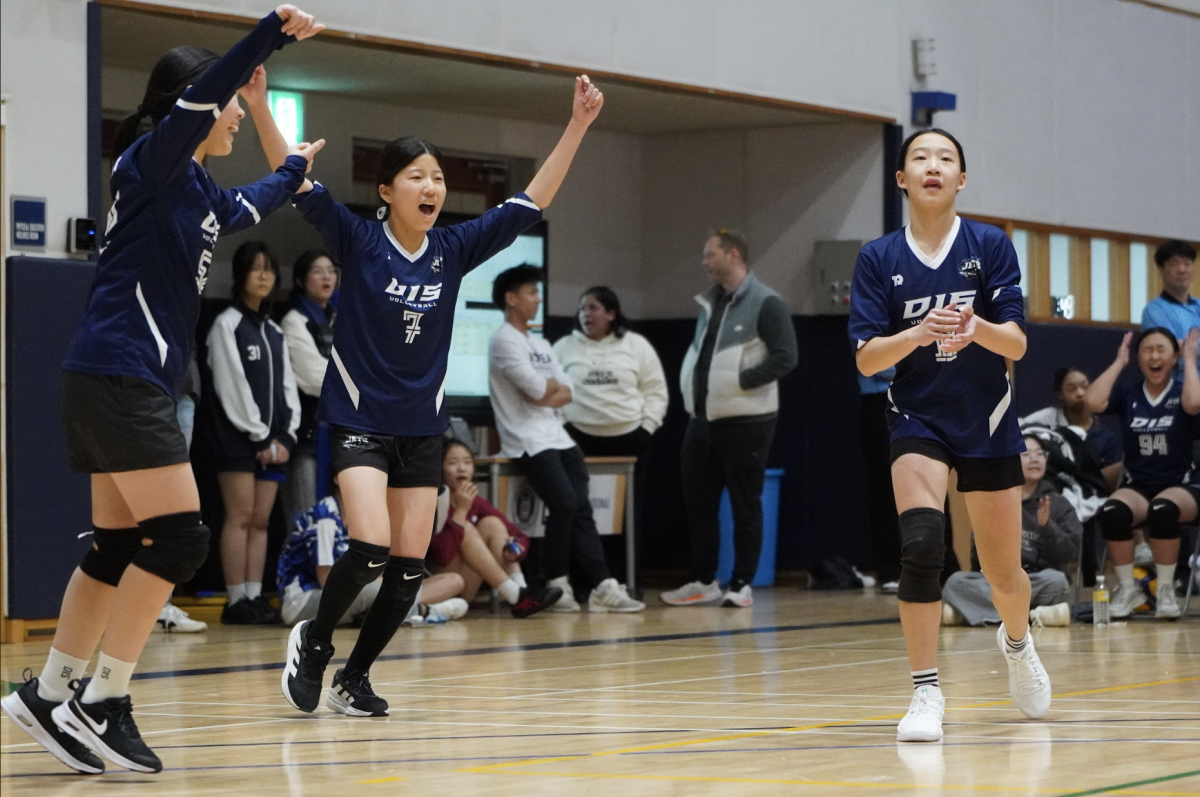 Seventh graders Christina Kim, Elin Koo, and Elly Song huddle for a triumphant cheer after a decisive point. They pour optimism onto to the court. 